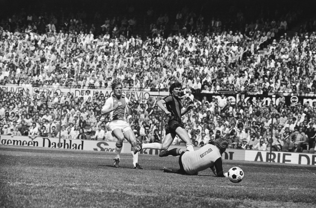 Schwarzes und wei├čes Foto von Fü├čballspielern in Aktion auf einem Feld mit Zuschauern im Hintergrund und einer Bundesliga 1978-79 Ajax 1-1 Hannover 96-Tafel.