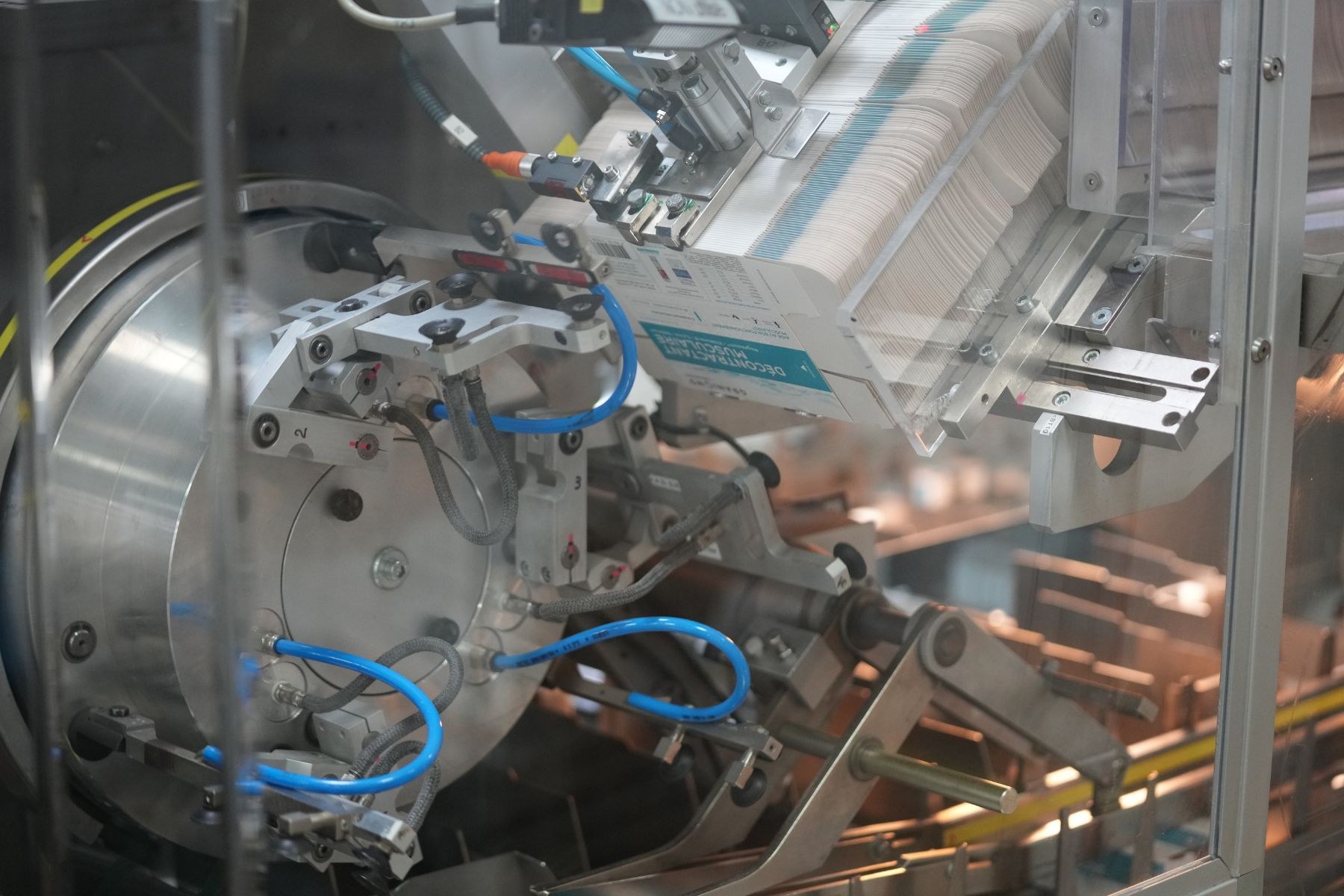 Automatisiertes Verpackungssystem-Maschine auf einem Fabriktor mit unscharfen Hintergrundobjekten.