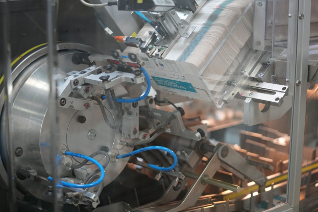 Automatisiertes Verpackungssystem-Maschine auf einem Fabriktor mit unscharfen Hintergrundobjekten.