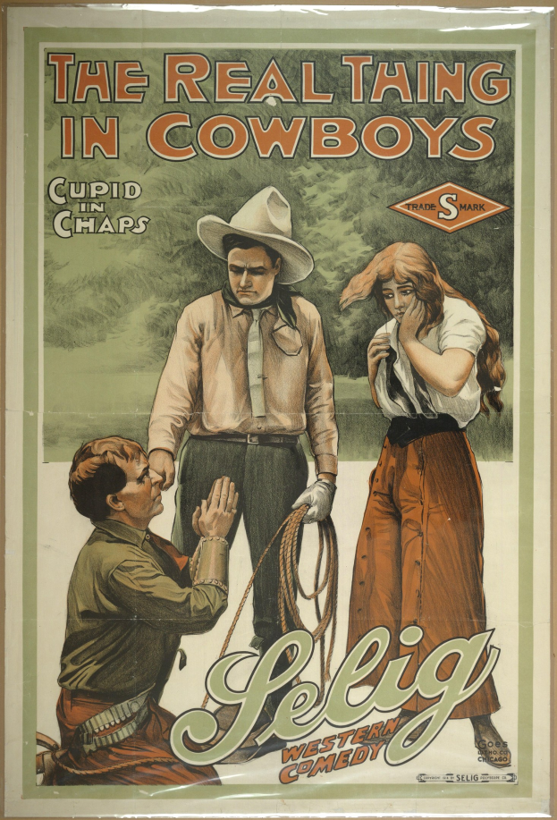 Plakat an einer Wand mit drei Personen – zwei Männer mit Cowboyhüten und eine Frau in einem langen Kleid – mit der Schrift "Das echte Ding bei Cowboys" in fetter schwarzer Schrift auf einem hellgelben Hintergrund.
