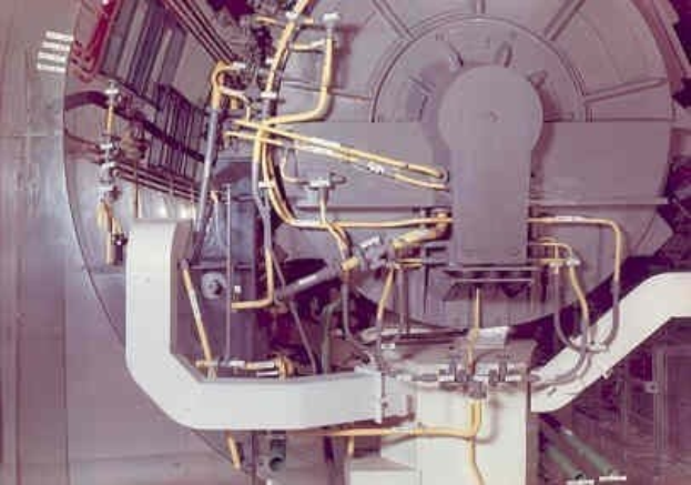 Großes industrielles Beschleunigergerät in einem Gebäude mit sichtbaren Komponenten und Verdrahtung.