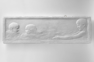 Drei Kinder beim Schwimmen in einem Pool mit einer Wand im Hintergrund.