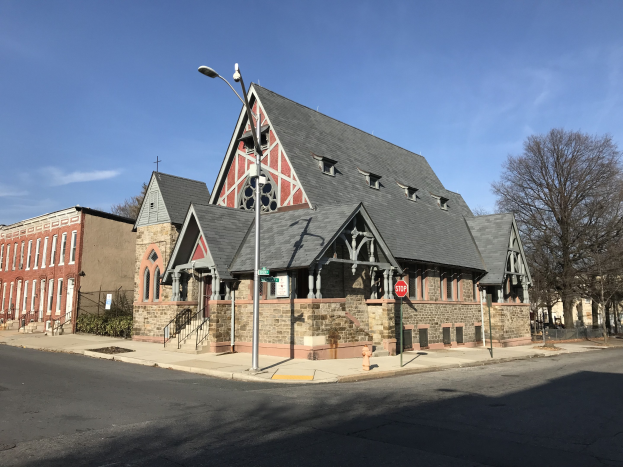 Alte Kirche an einer Straßenecke in St. Louis, Missouri, umgeben von Gebäuden, Fahrzeugen und Grün unter einem bewölkten Himmel.