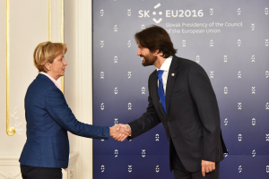 Bundeskanzlerin Angela Merkel und Bundespräsident Joachim Gauck schütteln Hände vor einem "EU-Gipfel"-Banner und lächeln freundlich.