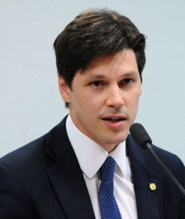 Ein Mann im Anzug spricht in ein Mikrofon an einem Rednerpult, wahrscheinlich um ein Gesetz zur Verbots des Internetsetzungs zu unterstützen.