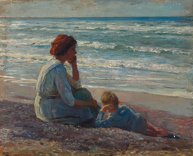 Eine Mutter in einem hellen Kleid und ein junger Junge sitzen auf einem goldenen Strand und sehen dabei zu, wie die Sonne über dem Ozean untergeht, während die Wellen an den Strand rollen.