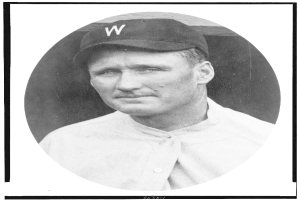 Ein Schwarz-Weiß-Foto von Joe DiMaggio, einem ehemaligen Spieler der Major League Baseball, der ein weißes Hemd und eine Mütze trägt.