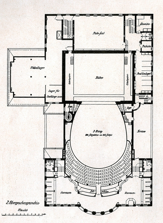 Schwarzes und wei├čes architektonisches Grundrissbild eines gro├čen Geb├Ąudes mit zahlreichen beschrifteten R├Ąumen, darunter ein Konzerthalle mit Buhne und Raumdimensionen.