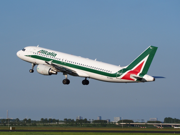 Alitalia Airbus A320-232 ERJ-EJZ Flugzeug beim Abheben vom Frankfurt Airport mit grünem Gras darunter, B├Ąumen und Geb├Ąuden im Hintergrund und einem klaren blauen Himmel.